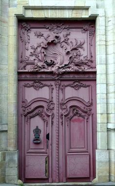 an ornately carved wooden door on the side of a building