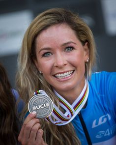 a woman holding up a medal in front of her face