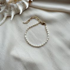 **Dainty Rice Pearl Bracelet Collection**   Discover the charm of simplicity with this collection of delicate rice pearl bracelets. Featuring high-quality pearls in elegant designs, these bracelets are perfect for adding a touch of sophistication to everyday or formal looks.   ### Key Pieces:   **Tiny Rice Pearl Bracelet**   A minimalist bracelet crafted with dainty rice pearls, this piece embodies understated elegance. Its subtle design makes it perfect for layering or wearing solo for a refined statement.   **Delicate Rice Pearl Bracelet**   This bracelet features small, smooth rice pearls strung together in a graceful design, offering a timeless and feminine accessory ideal for any occasion.   **Baroque Pearl Bracelet**   Highlighting irregular baroque pearls, this bracelet celebrates t Pearl Bracelet Gold, Rice Pearls, Bracelet For Her, Pearl Bracelets, Bracelet Pearl, Gold Armband, Bracelet Diy, Minimalist Bracelet, Bracelet Crafts