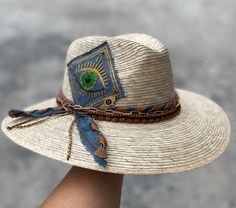 Unique palm hat embroidered by mexican artisans. Handmade of straw and beautifully embroidered by artisans in Mexico these hats are a must have if you want to stand of from the rest. They have an elastic band inside at the rim that makes them very comfortable and be worn from small to medium sizes. Dimensions: Small to Medium (54-55 cm *21 inches approx.) - (56-57 cm *22 inches approx.) Personalized Hats are made to order, allow 5 days  to deliver. Bohemian Palm Leaf Hat Bands For Vacation, Bohemian Palm Leaf Hat Bands For Summer, Embroidered Straw Hat For Beach With Short Brim, Artisan Woven Hat Bands For Summer, Spring Festival Palm Leaf Hats, Bohemian Straw Hat For The Beach, Bohemian Straw Hat For Beach, Handmade Fedora Hat Band From Toquilla Straw, Beach Sun Hat With Embroidered Short Brim