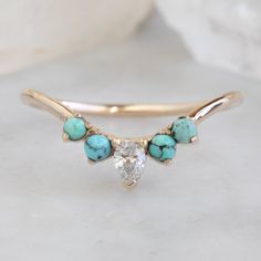 a gold ring with turquoise stones and a diamond