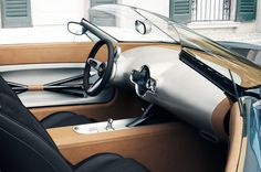 an interior view of a car with the dashboard and steering wheel showing, it appears to be made out of wood