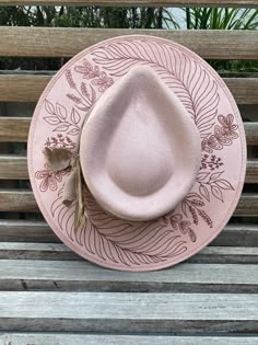 Pastel pink Fedora that was inspired by my garden. Burned leaves on the brim Accented with brown feathers, and a neutral peacock feather and natural stones.  Size Medium  Fedora Suede/Gamuza Band Toquilla of fabric/tela  Piedras Naturales Plumas de Pavo Real Pieza única Pink Fedora, Burned Hats, Sombrero Cowboy, Cowboy Hat Design, Hat Burning, Wood Burning Patterns Stencil, Custom Cowboy Hats, Hat Bar, Hat Blocks