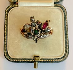 These Rococo rings with asymmetrical floral bezels reflected the mid-18th century taste for the light, elegant and graceful. This example is in high carat gold and silver with the giardinetti basket set with a harlequin array of gemstones that include rubies,table cut diamonds and an emerald in foiled closed back settings, amidst gold textured leaves. The ring measures 18mm by 16mm. The ring is sized a British L / USA 5¾ but is resizable up or down and still in immaculate condition. Victorian Rose Cut Diamond Ceremonial Rings, Victorian Ceremonial Ring With Rose Cut Diamonds, Elegant Formal Rings With Historical Design, Elegant Historical Design Rings For Formal Occasions, Elegant Rings With Historical Design For Formal Occasions, Victorian Style Flower Ring For Wedding, Vintage Wedding Rings With Jewels