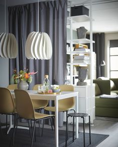 a dining room table with chairs and vases on it