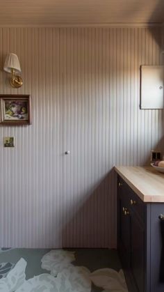 a bathroom with a sink and mirror next to a wall mounted light on the wall