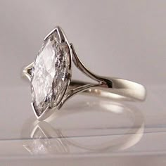 a white diamond ring sitting on top of a table