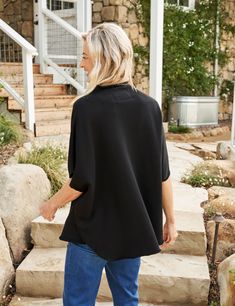 This airy capelet is perfect for those hint-of-spring days: sleeveless to catch the breeze and relaxed in fit with a gently-rolled funnel neck that adds a pop of polish to any look. This capelet top effortlessly combines style and comfort. Black Oversized Cape For Spring, Oversized Black Cape For Spring, Oversized Chic Cape For Spring, Chic Oversized Cape For Spring, Chic Black Cape For Spring, Spring Black Outerwear With Batwing Sleeves, Spring Black Batwing Sleeve Outerwear, Casual High Neck Outerwear For Spring, Spring High Neck Outerwear For Layering