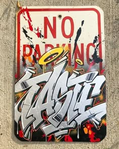 a no parking sign covered in graffiti on the side of a building with spray paint