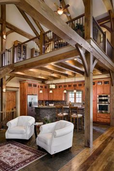 a living room filled with white furniture and wooden beams on top of each other's walls