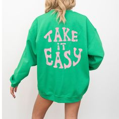 Embrace the nostalgic vibes with our "Take It Easy" crewneck sweatshirt in green, a perfect addition to your Y2K hoodie collection that radiates positivity and preppy aesthetic. This trendy pullover, adorned with an uplifting quote, is more than just a piece of clothing; it's a statement of ease and style. MATERIAL AND CARE  - Gildan 18000 -50% cotton, 50% polyester -Runs true to size - size up 1-2 sizes for an oversized look -Wash Inside Out In Cold Water PROCESSING AND SHIPPING  In effort to b Green Long Sleeve Sweatshirt With Graphic Print, Green Long Sleeve Sweater With Letter Print, Oversized Green Sweatshirt With Ribbed Cuffs, Green Long Sleeve Sweatshirt For Streetwear, Green Crew Neck Sweater For Streetwear, Green Graphic Print Crew Sweatshirt, Green Long Sleeve Hoodie With Letter Print, Green Letter Print Crew Sweater, Green Crew Neck Sweater With Letter Print