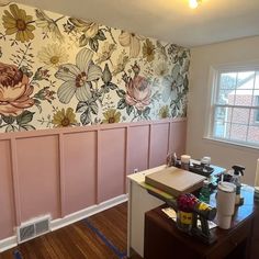 a room with pink paneling and flowers painted on the wall next to a window