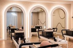 a salon with chairs, mirrors and lights on the walls in front of them is empty