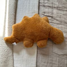 a brown teddy bear laying on top of a bed