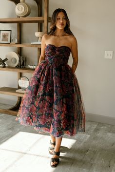 The Mariah Navy Floral Tulle Midi Dress is a romantic and elegant statement piece. Featuring tulle fabric with a stunning floral print in navy, rust, red, and mustard, this dress boasts a flattering A-line silhouette and a midi length that adds a graceful touch. The twist sweetheart neckline and strapless design create a feminine and timeless look, while the navy lining ensures comfort. A monochrome back zipper with hook closure provides a seamless fit, making the Mariah dress perfect for specia Tulle Midi Dress, White Bodycon Dress, Travel Dress, Jumpsuit Shorts Rompers, Vacation Dresses, Tulle Fabric, Maxi Dresses Casual, Navy Floral, Guest Dresses