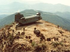 an army helicopter sitting on top of a hill