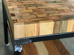 a close up of a wooden table with metal legs and wood planks on it