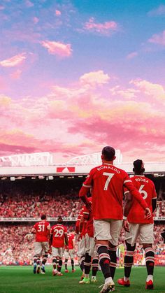 two soccer players in red and white uniforms are standing on the field with their arms around each other