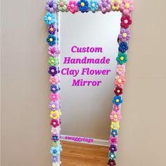 a mirror that has flowers on it and the words, custom handmade clay flower mirror