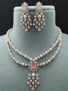 Step into elegance with our 2 Layer Pendant AD Necklace Set, part of our Luxe Royal Heritage collection, a stunning fusion of luxury and grace. Crafted meticulously, this necklace set captures the essence of American chic and Indian artistry. The soft hues of pink and radiant gold intertwine seamlessly, offering a touch of opulence to any ensemble. Lightweight and refined, they embody sophistication and cross-cultural allure, making every moment a statement of timeless beauty. Handcrafted Metal: Luxury White Kundan Necklace With Intricate Design, Luxury Gold Fusion Jewelry Sets, Elegant Pink Hand Set Jewelry Sets, Elegant Pink Necklace For Reception, Hand Set Pink Necklace For Celebrations, Pink Hand Set Necklace For Celebration, Pink Hand-set Necklace For Celebrations, Pink Diamond Jewelry Sets For Wedding, Elegant Pink Necklace For Formal Occasions