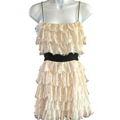 This charming Forever 21 dress combines delicate lace with playful ruffles, creating an elegant yet youthful look. The peach/ivory lace over black accents offers a striking contrast, ideal for making a statement. Its medium size provides a comfortable fit, while the spaghetti straps add a feminine touch.  The beading on the straps are in good shape with the exception of one spot.  The beads are intact...just needs a couple of stitches to tack down the beads.  There is also some separation at the bottom of the zipper that needs a few stitches on each side.  Price reflects condition. * Medium size for a comfortable fit   * Lace ruffles for an elegant look   * Black waistband for contrast   * Spaghetti straps for style   * Ivory color for versatility Style: Eyelash Lace, Whimsigoth, Retro Sty Spring Tiered Lace Dress With Ruffles, Summer Tiered Lace Dress With Ruffle Hem, Summer Tiered Lace Dress With Ruffles, Beige Ruffled Lace Dress For Party, Summer Party Lace Dress With Ruffles, Chic Tiered Lace Dress With Ruffles, Spring Party Lace Dress With Ruffles, Chic Tiered Ruffle Lace Dress, Spring Party Lace Dress With Ruffle Hem