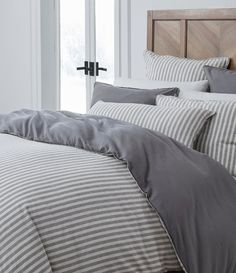 a bed with grey and white striped sheets