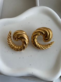 ✨Embrace the art of seduction with our Taylor Gold Earrings. ✨These stunning pieces are a masterclass in modern elegance, featuring a twisted, spiral design that wraps around your earlobe with a sultry allure. ✨The Taylor earrings are not just an accessory—they're an invitation to indulge in your most glamorous fantasies. ✨Their bold, sculptural form creates a mesmerizing effect, ensuring all eyes are on you. Perfect for the woman who dares to stand out, these earrings are the ultimate statement Elegant Swirl Earrings As Gift, Be Unforgettable, Spiral Design, All Eyes, All About Eyes, Master Class, Modern Elegance, Gold Earrings, Confidence