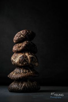 a stack of rocks sitting on top of each other in front of a black background