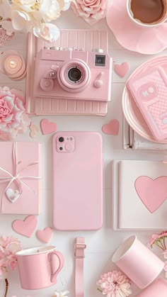 a pink phone case sitting on top of a table next to flowers and other items