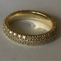 a close up of a gold ring on a white surface with lots of sparkles