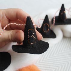 a hand is holding a small black witch hat