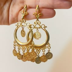 Hi there! A fine set of earrings from the Arabian heritage. 21K gold plated with coins. Wear it to your photoshoot, henna party, or as a wedding guest. Or on Eid! This piece falls under the category of gold imitation. It has the same design as real gold pieces sold in the Middle East. Enjoy it! Since this piece is gold plated, please wear it gently as its color should last you much more than any other piece of jewelry. Please avoid washing or scratching the plating away, and keep out of contact with creams and perfumes.  Any question? Want this as a gift to someone? Please message me! I will be very happy to help. Since I am just starting off this business, please know that no returns, refunds, or cancellations will be supported. Thanks for your understanding! Gold Earrings Arabic Design, Arab Earrings, Arabian Jewelry Gold, Gold Jewelry Middle East, Arabian Earrings, Middle Eastern Earrings, Arabic Earrings, Arabic Jewelry Traditional Gold, Middle Eastern Earrings Gold