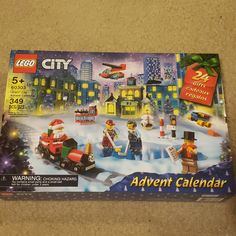 the lego city christmas calendar is displayed in front of a snowy scene with toys and gifts