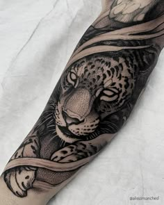 a black and white tattoo of a tiger on the arm