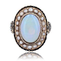 Ring in 18 karat yellow gold, owl hallmark. Beautiful and rare antique ring, it is decorated with an opal cabochon in the center of a chased decoration, surrounded by half fine pearls and a border of black and white enamel. The start of the ring is large, formed by small scales partially enameled black and white. Total weight of the opal : about 2.50 carats. Height : 20.5 mm approximately, width : 15.6 mm, thickness : 4.3 mm approximately, width of the ring at the base : 2 mm approximately. Weig Collectible Yellow Gold Opal Ring Oval Cabochon, Collectible Oval Cabochon Opal Ring In Yellow Gold, Heirloom Oval Cabochon Opal Ring, Oval Cabochon Enamel Ring Collectible, Antique Oval Cabochon Opal Ring, Heirloom Style Formal Opal Cabochon Ring, Antique Opal Ring With Oval Cabochon, Heirloom Style Cabochon Opal Ring For Formal Occasions, Antique Opal Ring With Oval Cabochon Gemstone