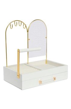 an open white box with a mirror and gold handles on it's sides, sitting on a white surface