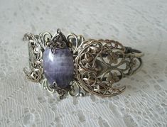 This beautiful antique brass filigree cuff bracelet has an antique brass triple moon design and amethyst setting. Adjustable. Bohemian Antique Gold Bracelets For Gift, Adjustable Antique Finish Spiritual Jewelry, Handmade Crescent Antique Jewelry, Handmade Antique Crescent Jewelry, Adjustable Antique Finish Jewelry Bracelet, Antique Handmade Crescent Jewelry, Adjustable Antique Finish Bracelet, Spiritual Bronze Bracelet Jewelry, Vintage Amethyst Jewelry For Healing