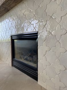 a fireplace in a room with white walls and tile flooring on the outside wall