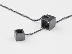 Two open cubes. Innovate design. The small cube slides through the big cube. The pendant and the necklace are made from 925 Sterling silver. The necklace has no closure behind the neck because the cubes can be moved into each other to open and close the necklace. The necklace has a length of about 82 cm (32 inch). The cube has a side legnth of about 9 mm (0,35 inch). In the shop we also offer the matching rings and earrings (have to be ordered separately). A perfect gift. Accordingly, the piece of jewelry is always ready gift packaged in a jewelry box. Geometric Black Necklace For Gift, Black Geometric Necklace For Gift, Moving Jewelry, Math Jewelry, Urban Jewelry, Cube Necklace, Metalwork Jewelry, Silver Jewelry Design, Geometric Necklace