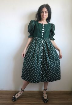 "Vintage Austrian folk dress by Distler Original. Traditional princess style with fitted bodice, puffed short sleeves (elastic in the bottom shaping a ruffle) and full pleated skirt. The bodice is green linen-cotton blend.  Features sweetheart neckline and pointed waist. The sleeves and the skirt made with 2 different but matching printed cotton fabrics. White cotton lining on the bodice. Massive white buttons down the front. There are side slits in the skirt. The dress got side pockets! Also got sleeve puffers. This is a super-lovely dress in a rare-for-dirndls size XS. Please check the measurements: armpit  ~ 86 cm  /  ~  33 \"  waist ~ 68 cm  /  ~ 26 \"  length  ~ 114 cm  /  ~  44.5 \"  In great vintage condition." Fitted Patchwork Puff Sleeve Dresses, Fitted Peasant Prairie Dress Costume, Fitted Full Skirt Victorian Dress In Vintage Style, Fitted Full Skirt Vintage Victorian Dress, Vintage Full Skirt Costume Dress, Fitted Vintage Victorian Dress With Full Skirt, Fitted Cotton Prairie Dress With Smocked Bodice, Green Puff Sleeve Dress In Cottagecore Style, Bohemian Fitted Dress With Gathered Skirt