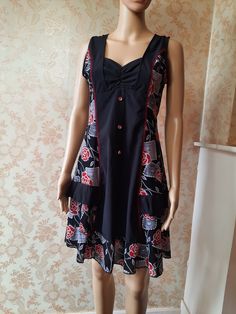 "Vintage black and floral shift dress. The front has a sweetheart neckline and 3 decorative red buttons,  it is sleeveless with red and grey flowers on the side panels and at the hem.  It has a side zip and is in good condition. Bust;  36\" Length;  35\" Made by  GLAMZ polyester\\elastin" Black Knee-length Vintage Dress For Summer, Black Knee-length Vintage Summer Dress, Black Vintage Knee-length Summer Dress, Black V-neck Dress With Rose Print, Black Sleeveless Vintage Summer Dress, Summer Sleeveless Black Vintage Dress, Summer Black Sleeveless Vintage Dress, Black Bohemian Dress With Buttons, Retro Rose Print Summer Dress