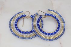 Handmade colorful boho statement earrings in the most gorgeous mix of cobalt blue, gold, and white. These artisan beaded hoop earrings were made with several sizes and shapes of seed beads. Each tiny bead is selected and hand sewn into place, one at a time with a needle and thread. No plastics, no glue, no looms - completely hand stitched with strong nylon thread.✔️Ear wires are gold filled✔️handmade in the USA✔️ships boxed and ready to gift in 3-5 business days ✔️lightweight & comfortable✔️LENG Blue Beaded Small Hoop Jewelry, Handmade Blue Beaded Hoop Earrings, Blue Beaded Small Hoop Earrings, Small Blue Beaded Hoop Earrings, Handmade Blue Beaded Small Hoop Earrings, Blue Small Hoop Beaded Earrings With Dangling Beads, Blue Small Hoop Earrings For Festival, Blue Small Hoop Earrings With Tiny Beads, Blue Hoop Beaded Earrings With Tiny Beads