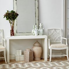 a white table with two chairs and a mirror