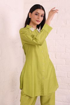 Elevate your wardrobe with this exclusive green cotton silk co ord set. Made from soft and breathable fabric, it offers a comfortable and relaxed fit that's perfect for any day wear. The solid plain design of the top and pants is simple yet stylish, featuring a shirt collar style with relaxed sleeves. Pair it with your favorite sneakers for a casual look or dress it up with some heels for a night out. With its high-quality material and excellent craftsmanship, this set will be your go-to outfit Cotton Silk Fabric, Shirt Collar Styles, Parrot Green, Green Tunic, Trouser Co Ord, Plain Tops, Plain Design, Silk Material, Pants Design