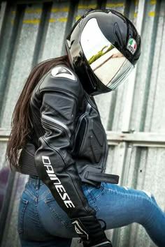 a woman wearing a motorcycle jacket and helmet