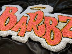 a close up of a cake with the word barboz written in large letters