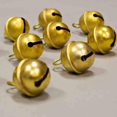 several golden bells with faces drawn on them