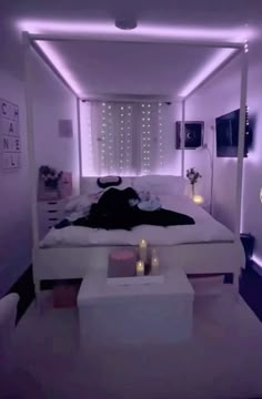 a white bed sitting under a purple light