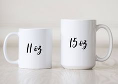 two white coffee mugs with numbers on them