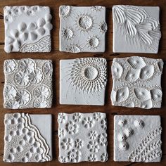 nine white ceramic tiles with intricate designs on them, all in different sizes and shapes